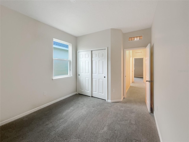 unfurnished bedroom with light colored carpet and a closet