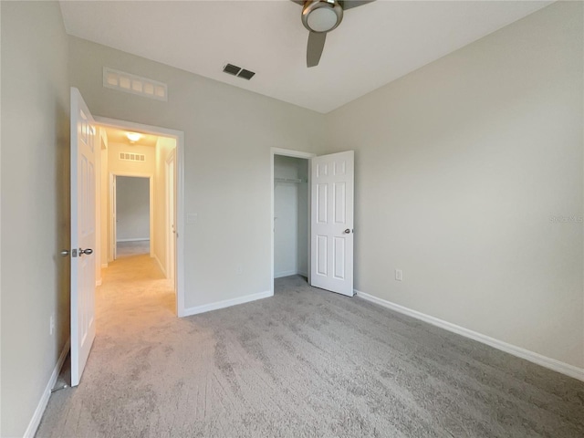 unfurnished bedroom featuring ceiling fan, light carpet, and a closet