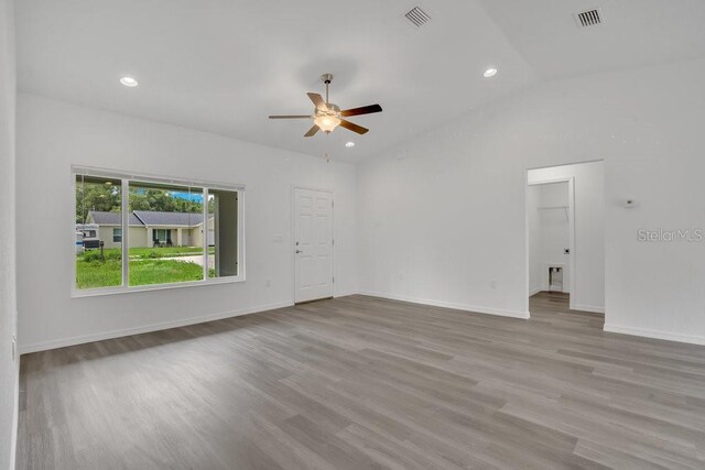 empty room with hardwood / wood-style flooring, vaulted ceiling, and ceiling fan