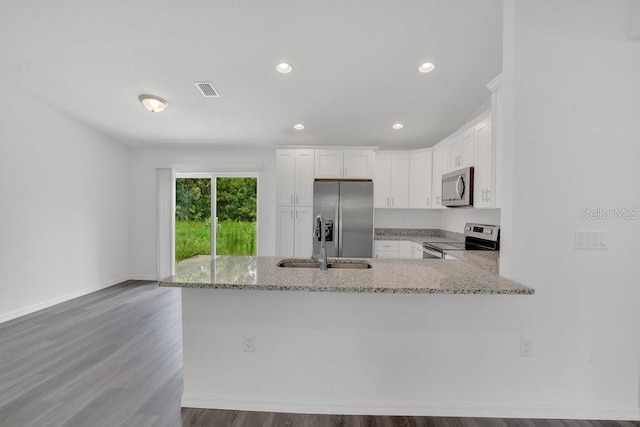 kitchen featuring white cabinets, dark hardwood / wood-style floors, light stone countertops, appliances with stainless steel finishes, and sink