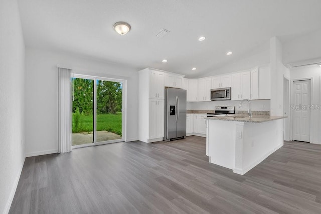 297 Malauka Run, Ocklawaha, FL 32179 - kitchen with white cabinetry, appliances with stainless steel finishes, light stone countertops, and light hardwood / wood-style floors