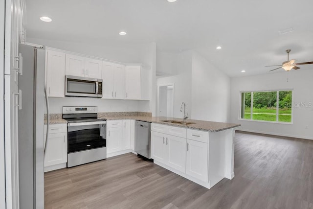 kitchen featuring light hardwood / wood-style flooring, stainless steel appliances, sink, kitchen peninsula, and ceiling fan