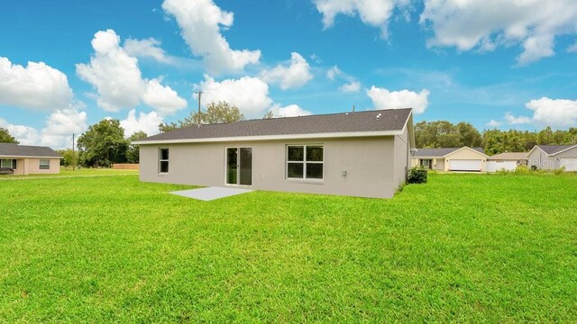 rear view of property with a patio and a lawn