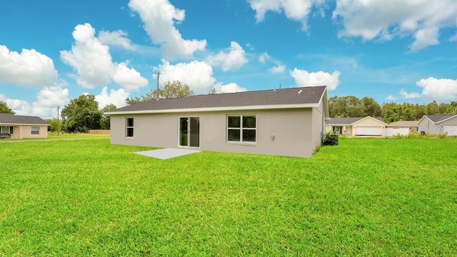 rear view of property featuring a patio and a lawn