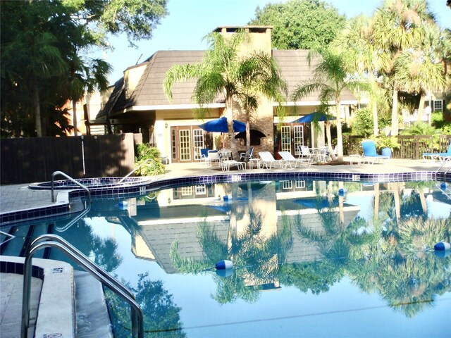 view of swimming pool with french doors and a patio