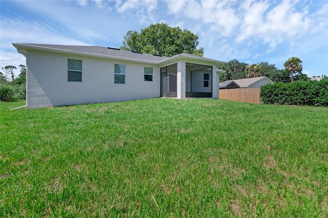 rear view of property with a lawn