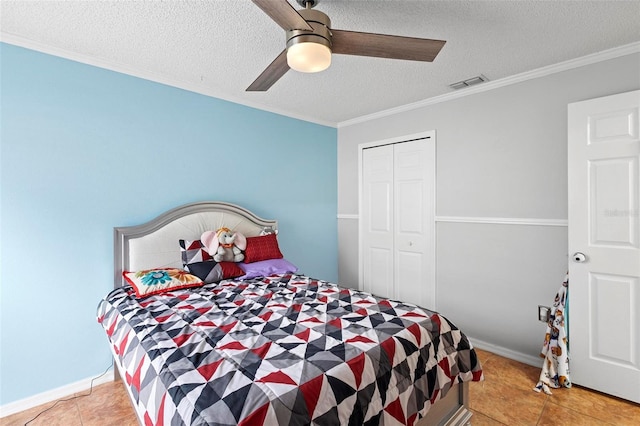 tiled bedroom featuring ceiling fan, a closet, crown molding, and a textured ceiling