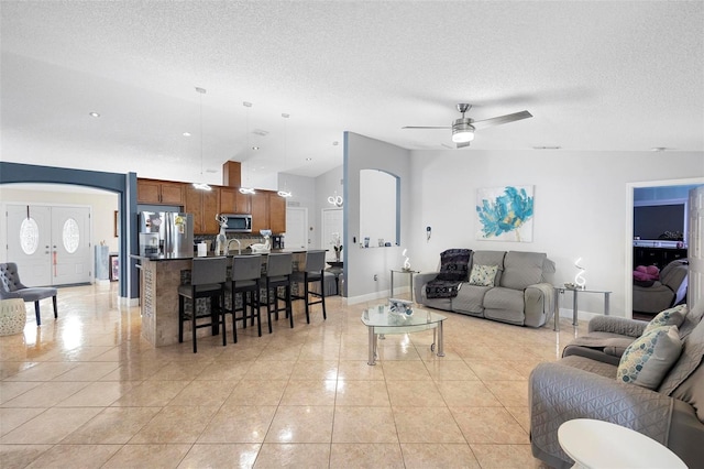 tiled living room with ceiling fan and a textured ceiling