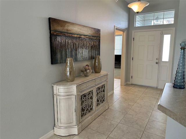 tiled foyer entrance with a towering ceiling