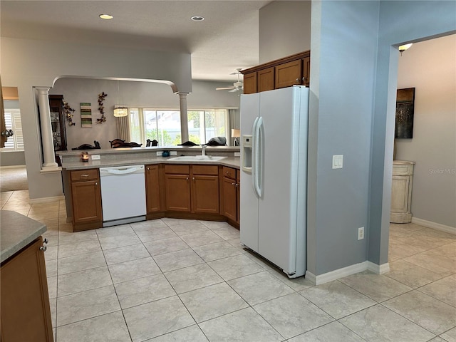 kitchen with white appliances, sink, ceiling fan, light tile patterned floors, and kitchen peninsula