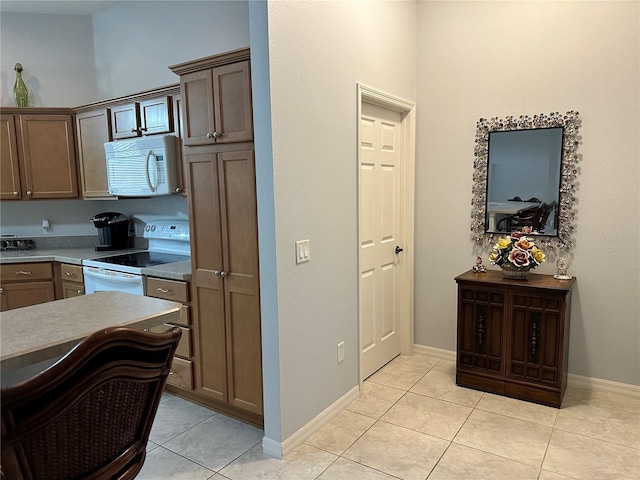 kitchen with white appliances and light tile patterned floors