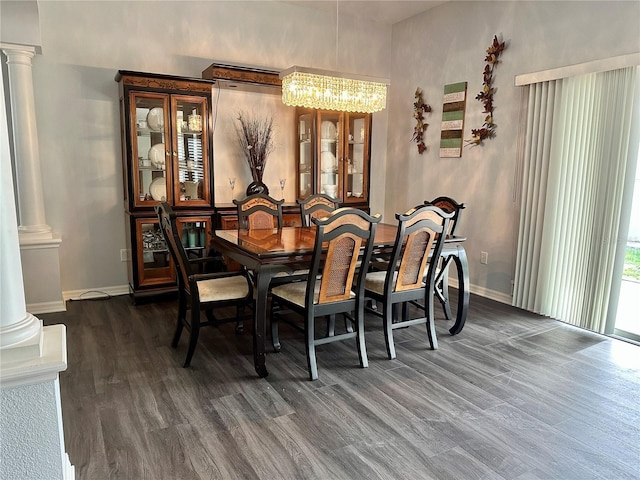 dining area featuring decorative columns, dark hardwood / wood-style floors, and an inviting chandelier