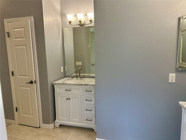 bathroom with tile patterned floors, vanity, and a notable chandelier