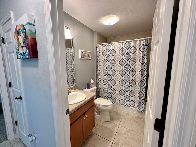 bathroom featuring tile patterned floors, vanity, toilet, and a textured ceiling