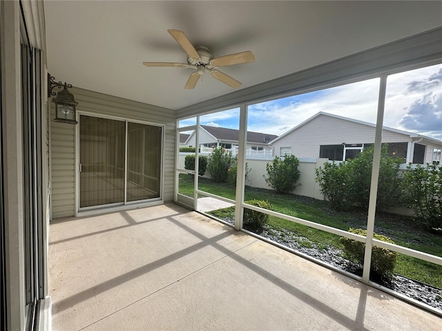 unfurnished sunroom featuring ceiling fan