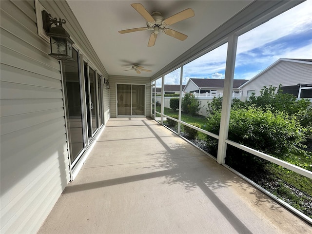 unfurnished sunroom with ceiling fan