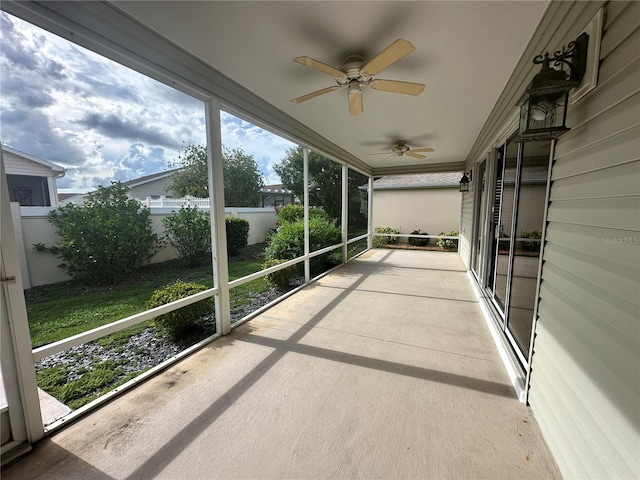 unfurnished sunroom with ceiling fan