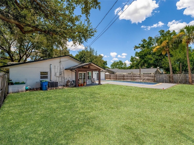 view of yard with a fenced in pool, a fenced backyard, a patio, and central air condition unit