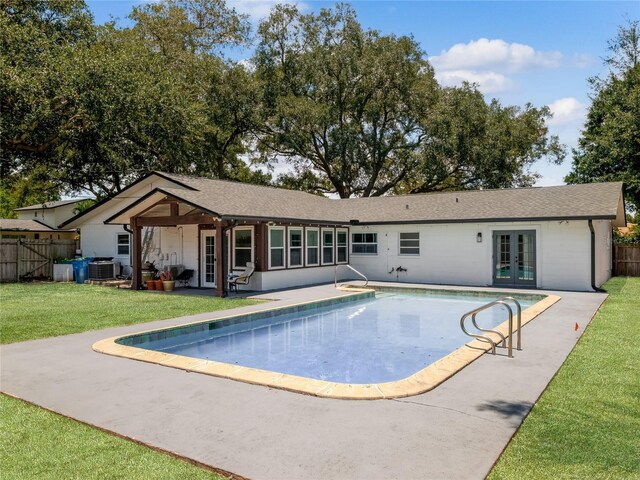 view of pool with a patio, french doors, a lawn, and fence