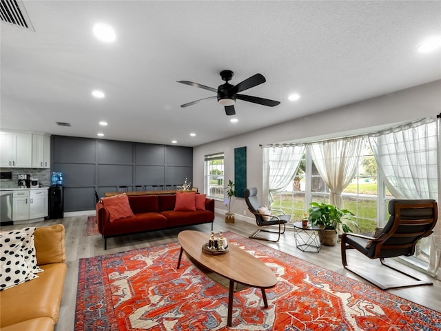 living area featuring light wood finished floors, visible vents, and recessed lighting