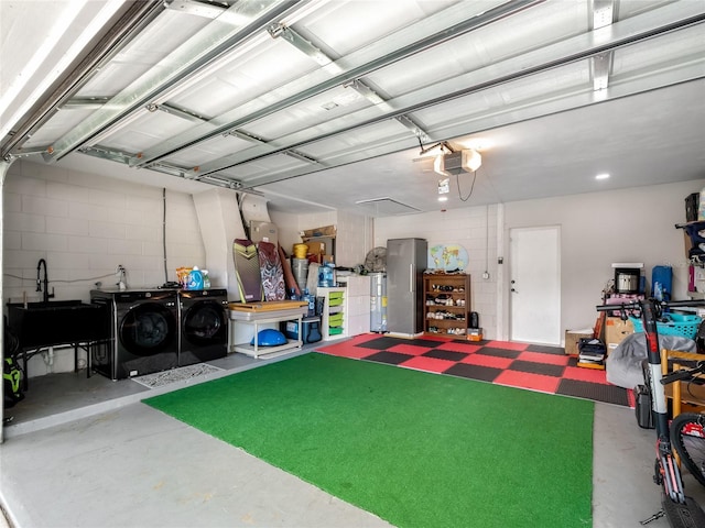 garage featuring a garage door opener, a sink, and independent washer and dryer