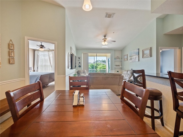 dining space with vaulted ceiling, carpet, and ceiling fan