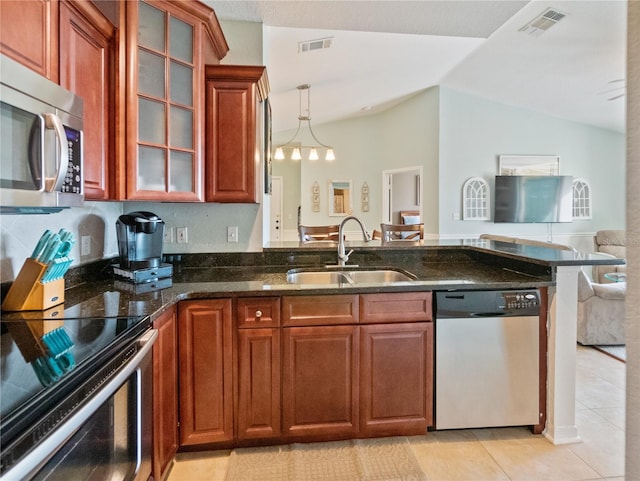 kitchen with decorative light fixtures, vaulted ceiling, light tile flooring, appliances with stainless steel finishes, and sink