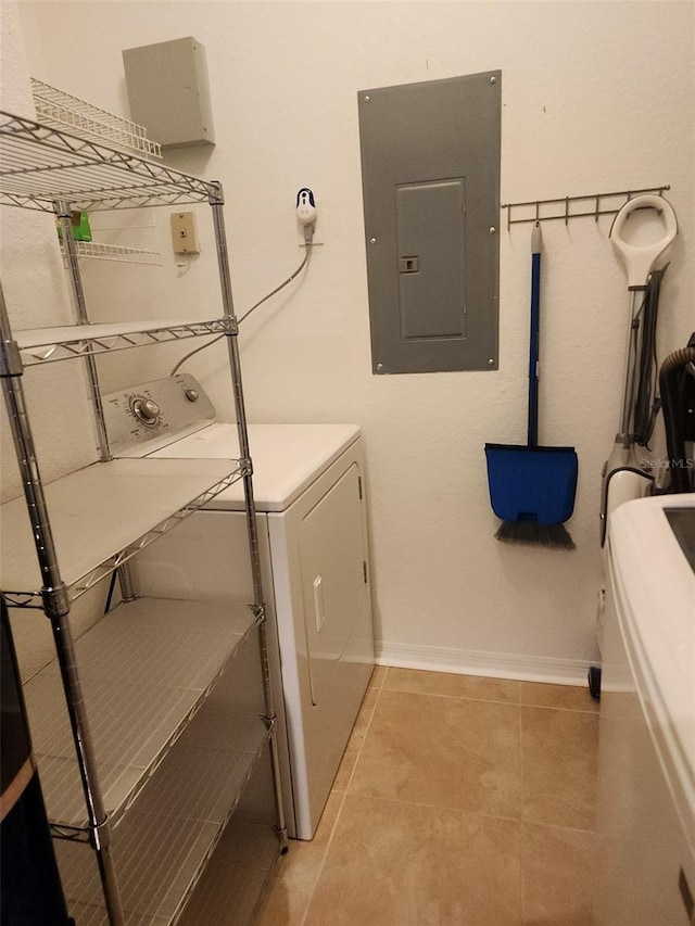 laundry area with washing machine and clothes dryer, electric panel, and light tile patterned floors