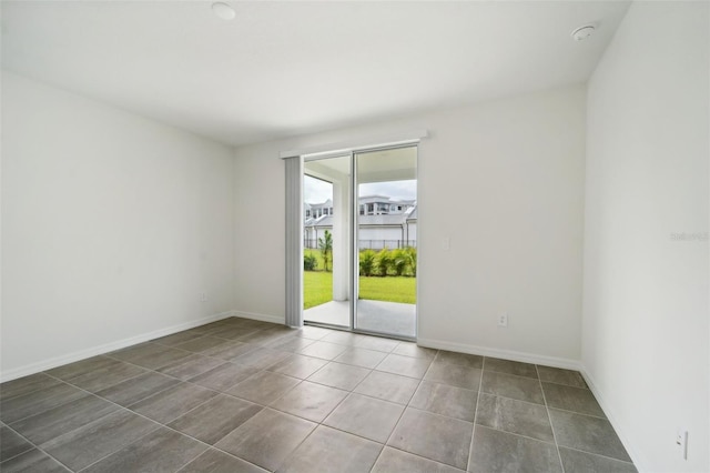 unfurnished room with dark tile patterned floors