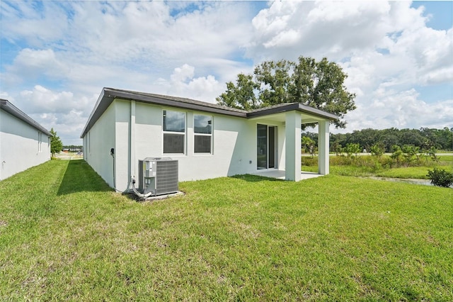 rear view of house with a yard and central AC unit