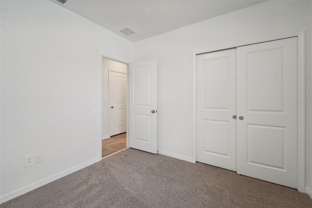 unfurnished bedroom featuring a closet and light carpet