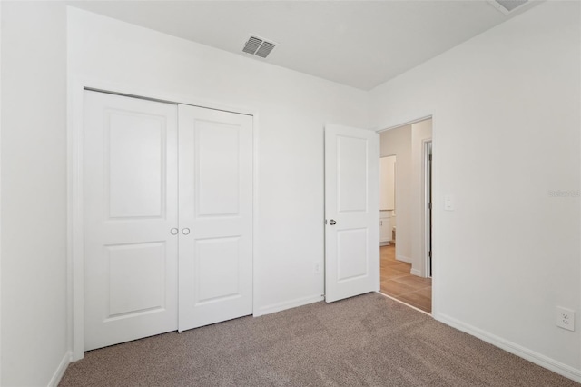 unfurnished bedroom featuring a closet and light carpet