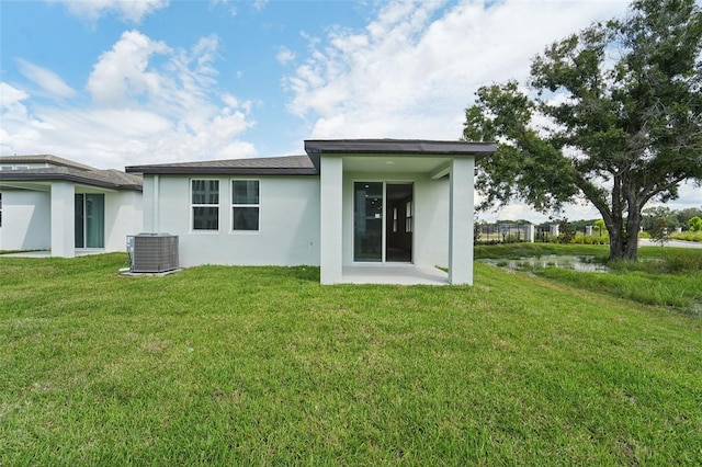 rear view of property with a yard, central AC unit, and a patio