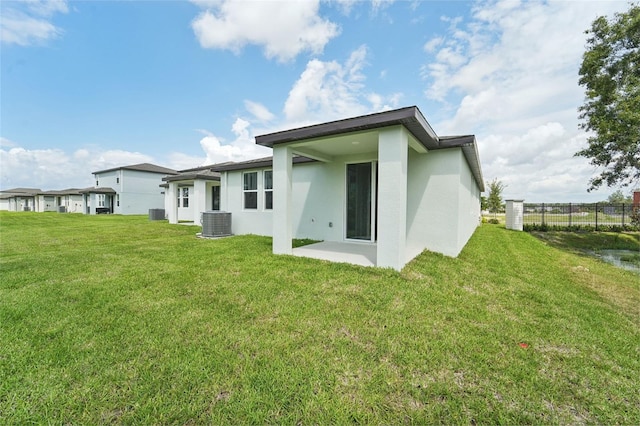 back of house featuring a patio, central AC unit, and a yard