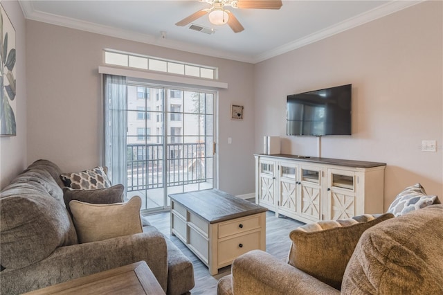 living room featuring ceiling fan, light wood-type flooring, and crown molding