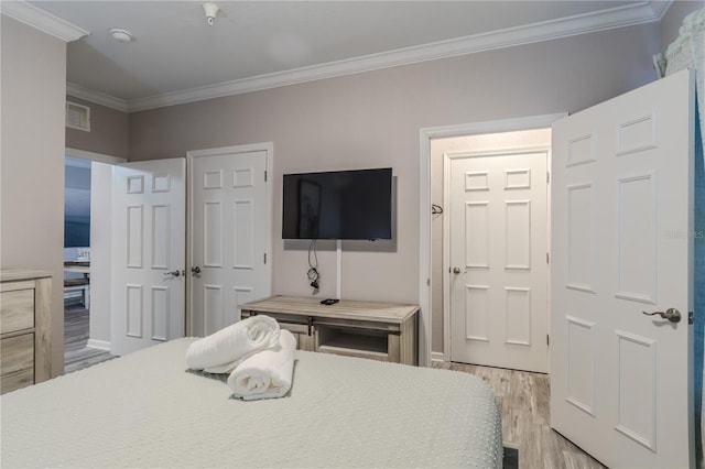 bedroom featuring ornamental molding and light hardwood / wood-style flooring