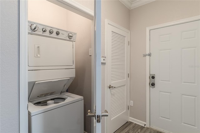 laundry room featuring stacked washer and clothes dryer, ornamental molding, and hardwood / wood-style floors