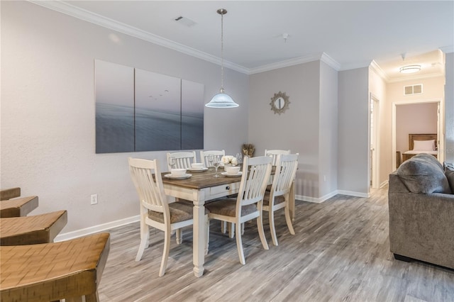 dining space with wood-type flooring and crown molding