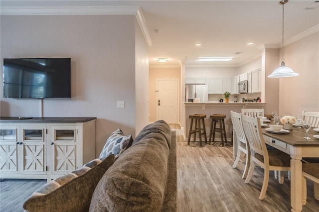 living room featuring ornamental molding and light hardwood / wood-style flooring