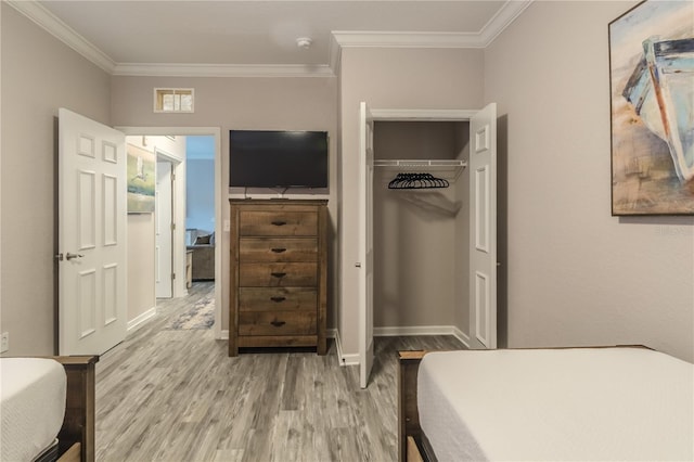 bedroom with light hardwood / wood-style floors, a closet, and crown molding