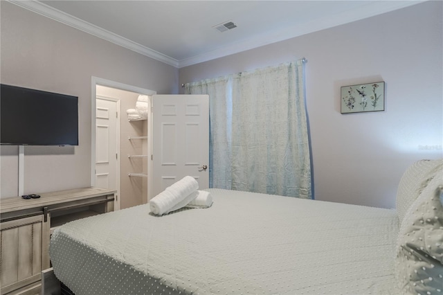 bedroom featuring crown molding and a walk in closet