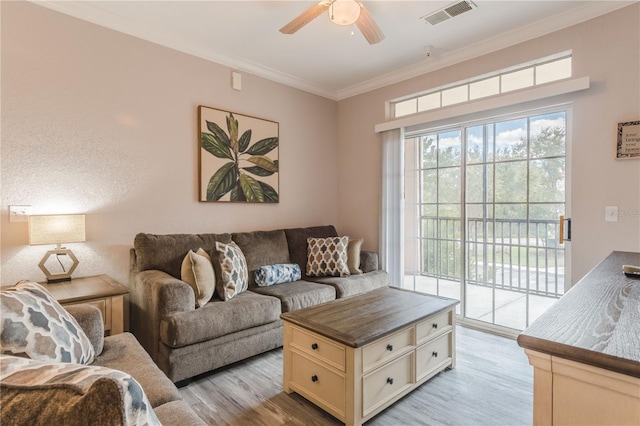 living room featuring ceiling fan, light hardwood / wood-style floors, and crown molding