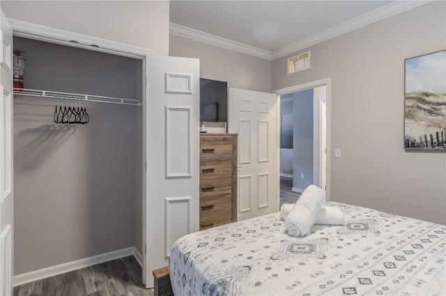 bedroom featuring dark wood-type flooring, a closet, and crown molding