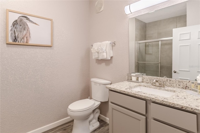 bathroom featuring wood-type flooring, vanity with extensive cabinet space, and toilet