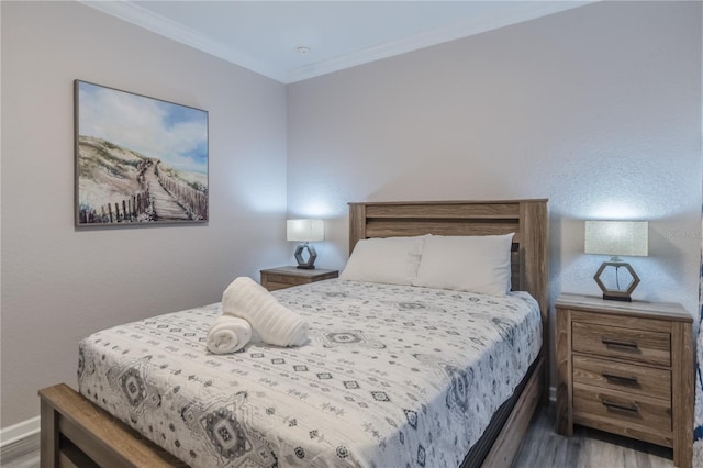 bedroom with ornamental molding and dark wood-type flooring