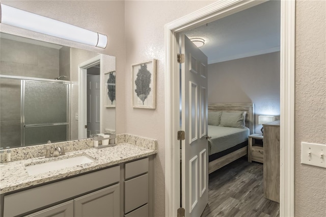 bathroom featuring crown molding, hardwood / wood-style flooring, and vanity