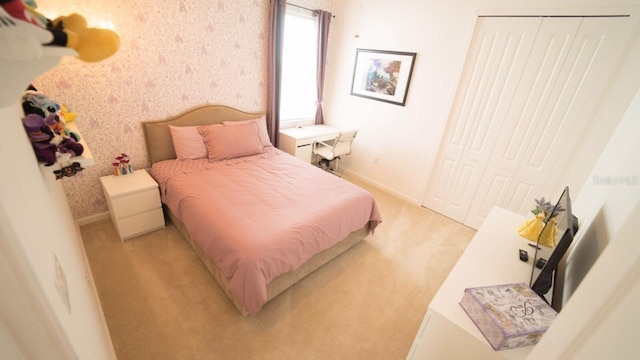 bedroom with light colored carpet and a closet