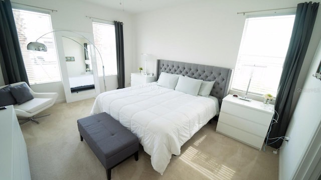 carpeted bedroom featuring multiple windows