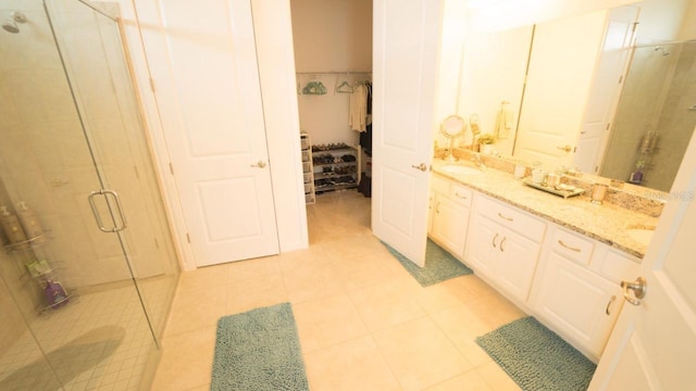 bathroom featuring a shower with door, vanity, and tile patterned flooring