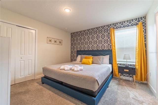 carpeted bedroom featuring a textured ceiling and a closet